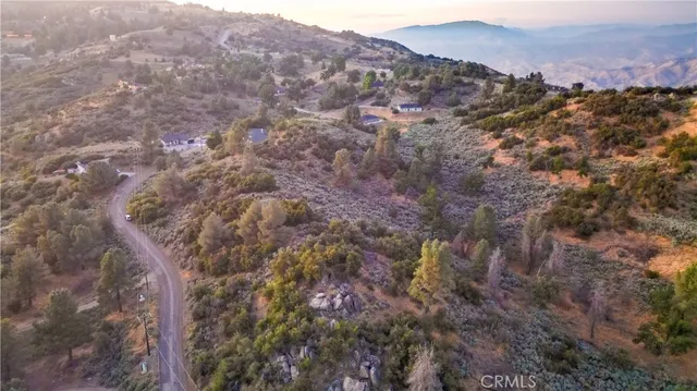 a view of a dry yard with mountains in the background