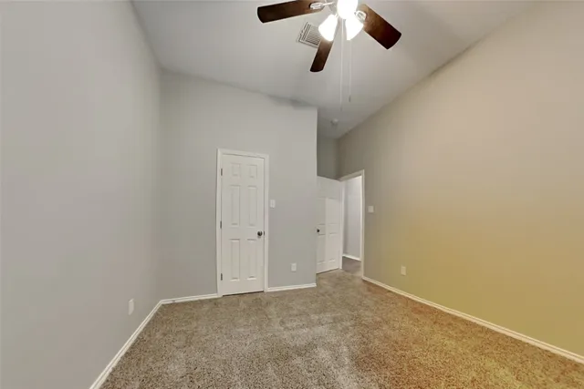 an empty room with a chandelier fan