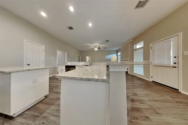 a large kitchen with stainless steel appliances kitchen island a large counter top and a stove top oven