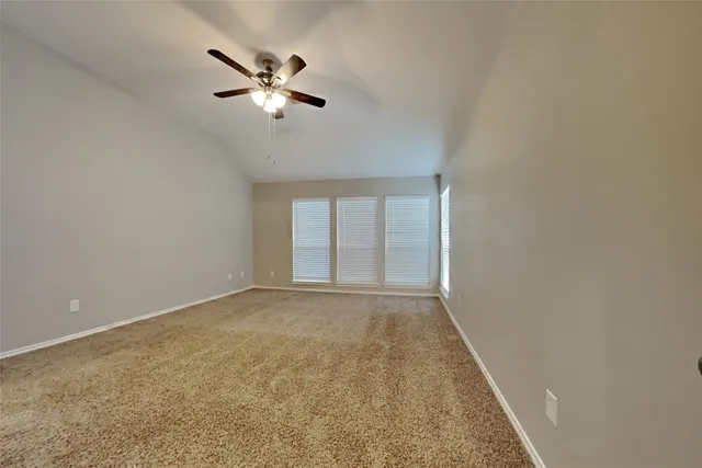 an empty room with closet and ceiling fan