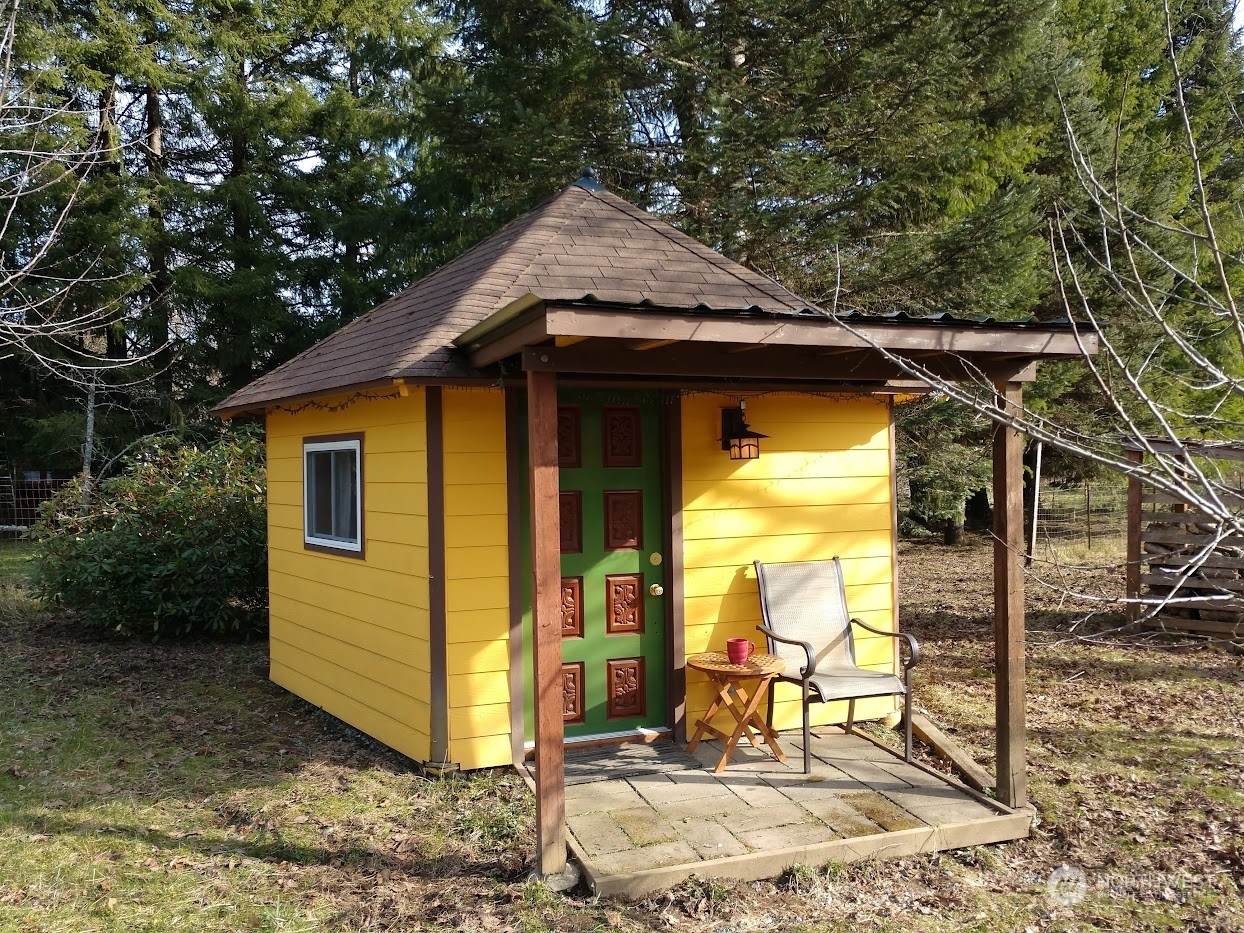 36922 Swede Heaven Road Arlington, WA 98223 - Photo 20 of 40 a view of a house with a wooden bench next to a yard