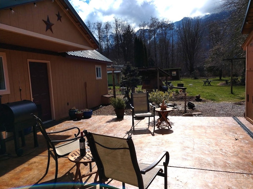 36922 Swede Heaven Road Arlington, WA 98223 - Photo 28 of 40 a view of backyard with table and chairs and a barbeque