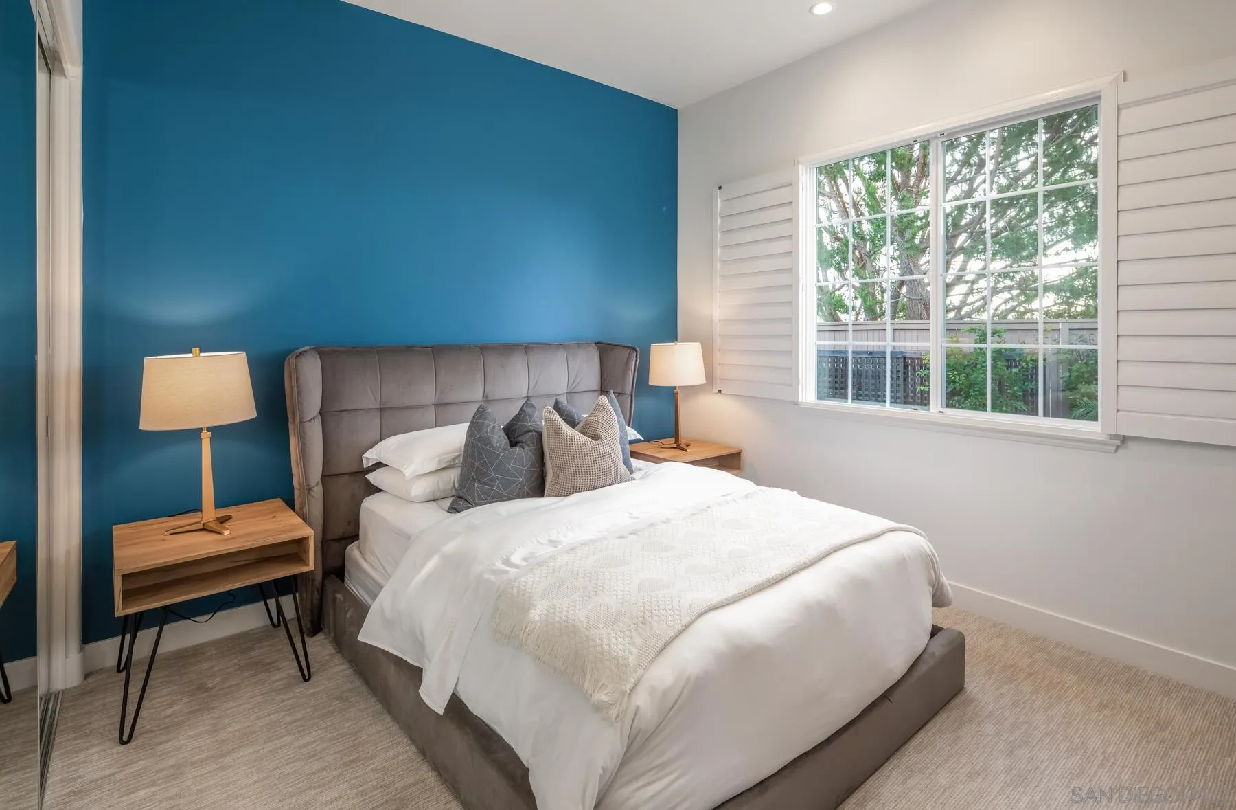 1355 Ravean Court Encinitas, CA 92024 - Photo 22 of 31 a bedroom with a bed a lamp and a window