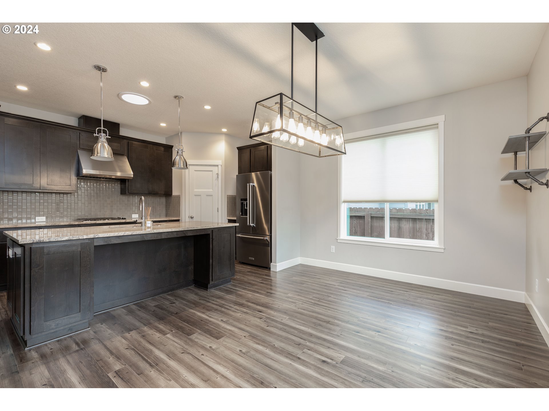 2714 Northeast 167th Circle Ridgefield, WA 98642 - Photo 8 of 35 a kitchen with stainless steel appliances granite countertop a refrigerator a sink dishwasher a stove and white countertops with wooden floor