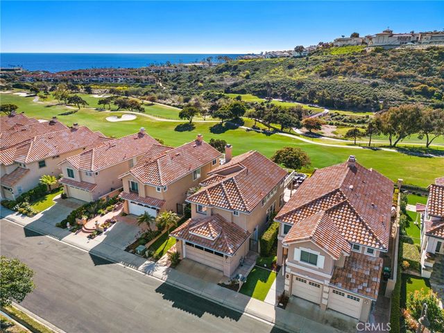 an aerial view of residential houses with outdoor space and ocean view