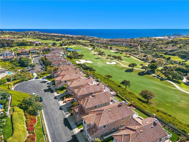 an aerial view of residential houses with outdoor space and ocean view
