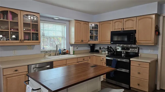 a kitchen with kitchen island a sink window and appliances