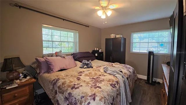 a bedroom with a bed and wooden floor