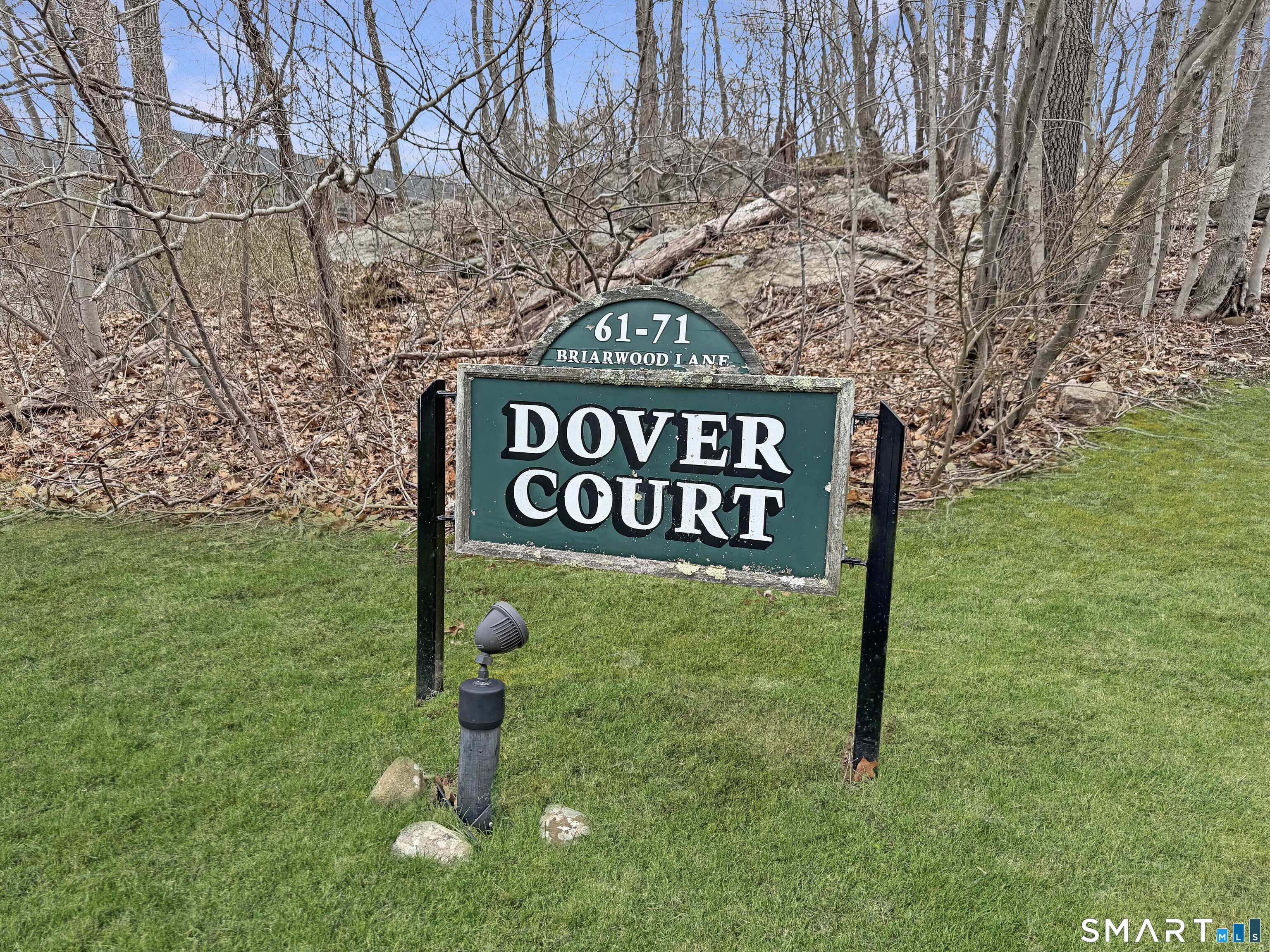 61 Dover Court, Unit B Branford, CT 06405 - Photo 1 of 14 a view of a street sign under a large tree
