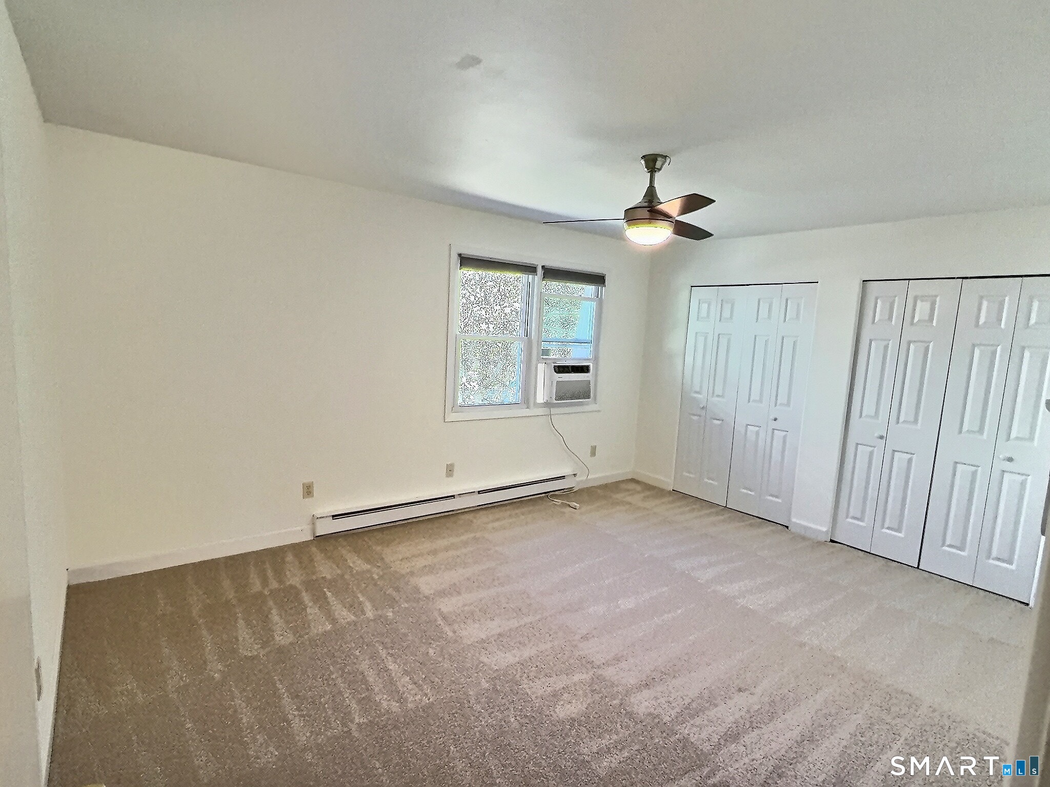61 Dover Court, Unit B Branford, CT 06405 - Photo 12 of 14 an empty room with chandelier fan and windows