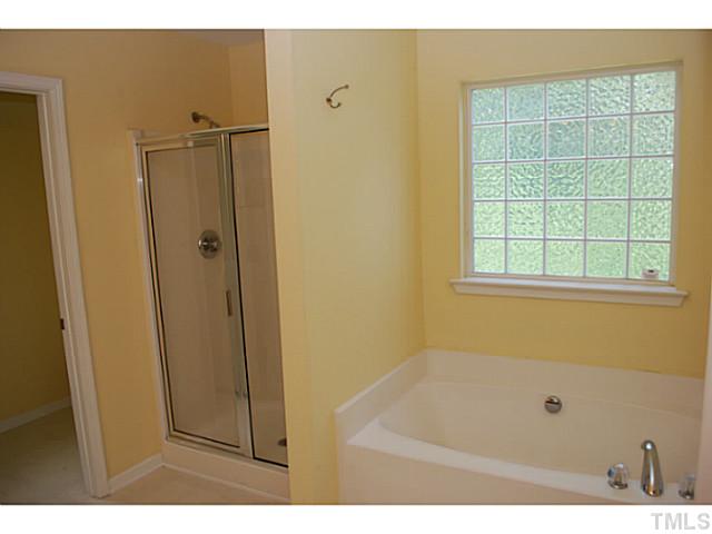 3117 Rendezvous Drive Raleigh, NC 27610 - Photo 13 of 22 a bathroom with a bathtub and a window