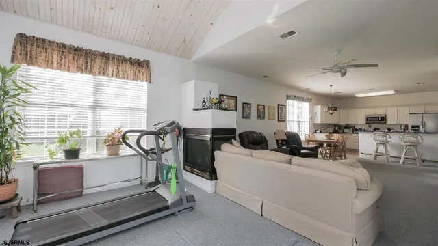 a living room with furniture a window and gym equipment
