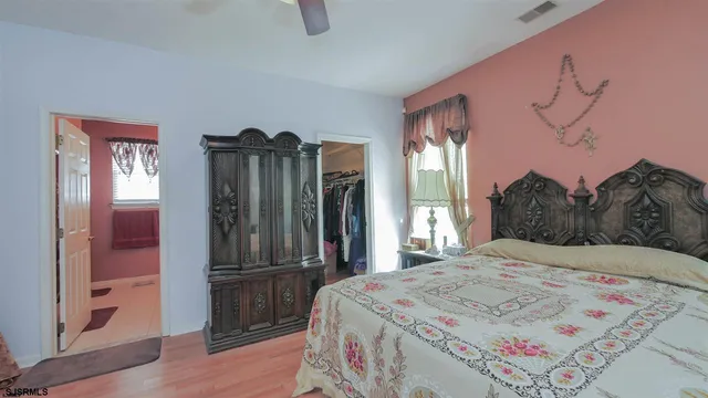 a bedroom with a bed dresser and a large mirror
