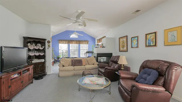 a living room with furniture a window and a flat screen tv