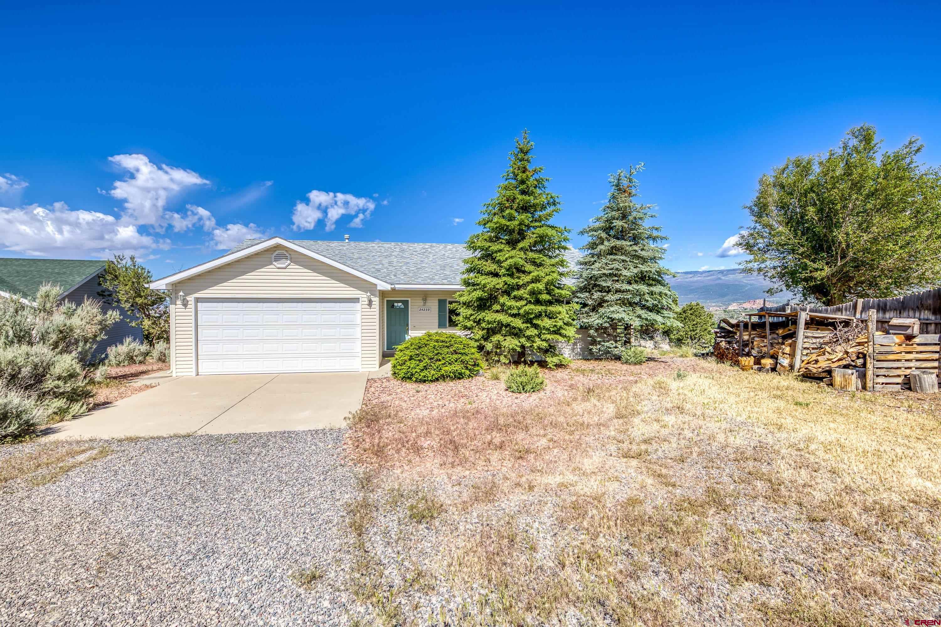 24239 Valley View Circle Cedaredge, CO 81413 - Photo 17 of 18 a front view of a house with a yard and garage