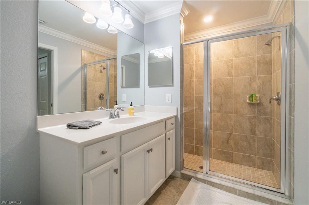 9590 Trevi Court, Unit 5317 Naples, FL 34113 - Photo 15 of 38 a bathroom with a granite countertop sink mirror and shower