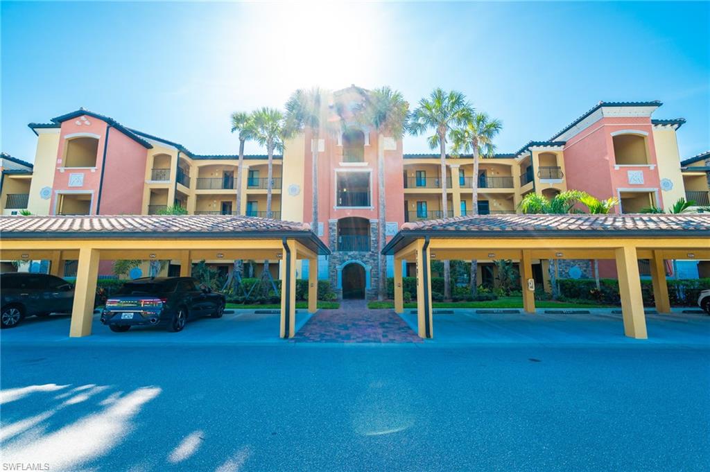 9590 Trevi Court, Unit 5317 Naples, FL 34113 - Photo 2 of 38 front view of a building with a garden