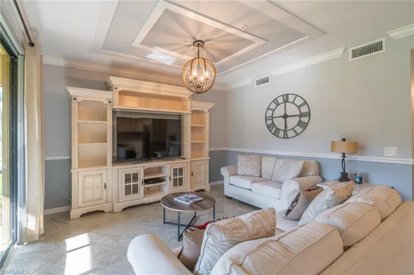 a living room with furniture a flat screen tv and kitchen view