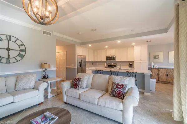 a living room with furniture and a view of kitchen