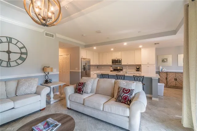 a living room with furniture and a view of kitchen