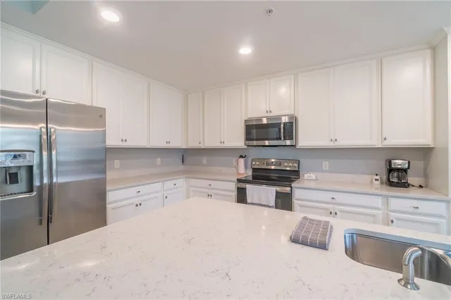 a kitchen with stainless steel appliances granite countertop a refrigerator sink and stove