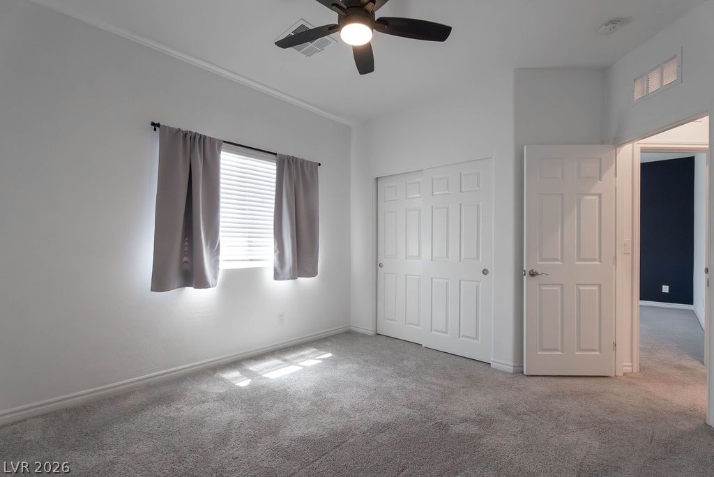 7126 Calvert Cliffs Street North Las Vegas, NV 89084 - Photo 31 of 44 A well-lit bedroom features plush carpeting and a convenient closet with bi-fold doors.