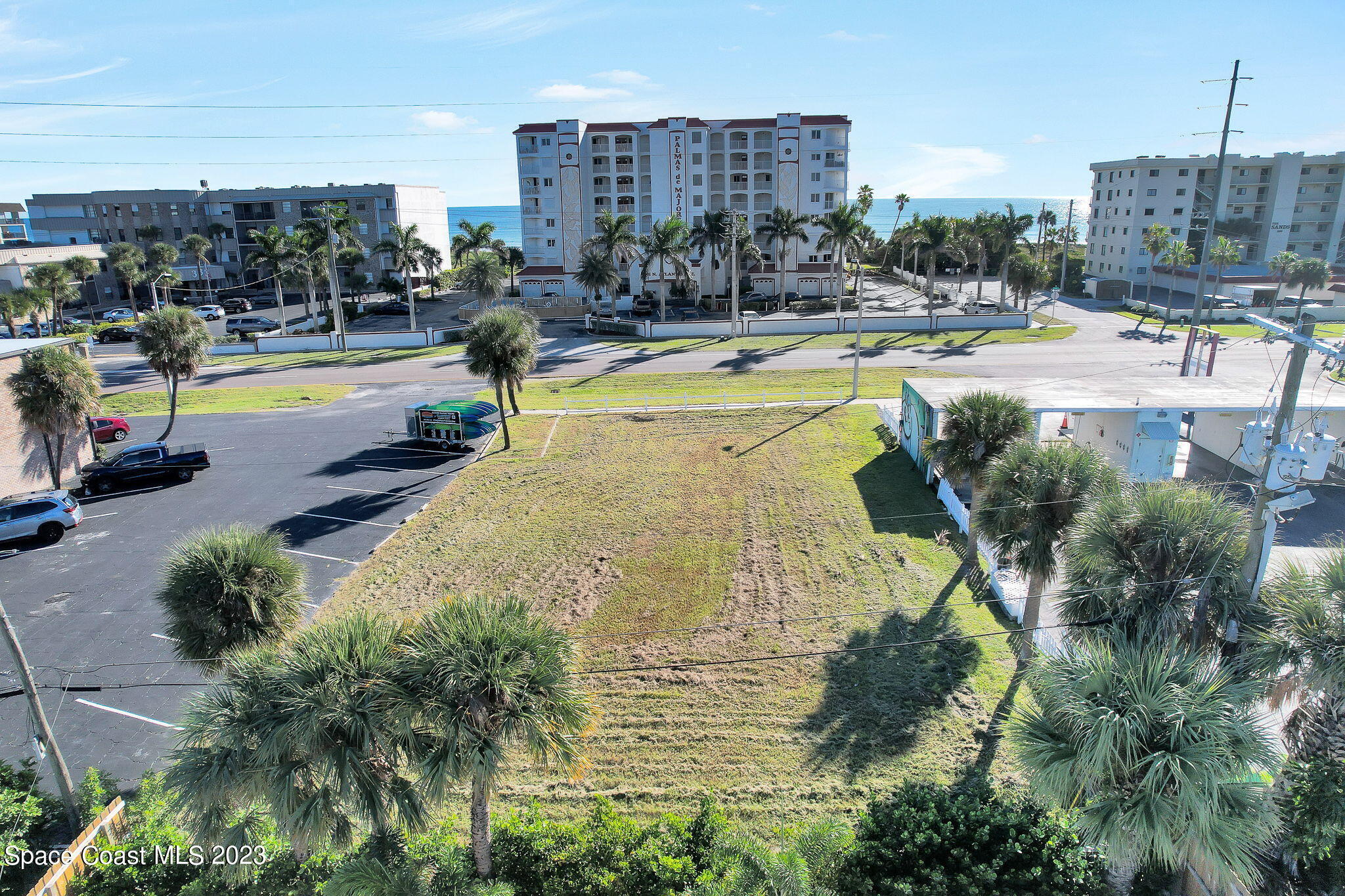310 North Atlantic Avenue Cocoa Beach, FL 32931 - Photo 2 of 11 a view of a swimming pool with a lawn chairs and palm tree