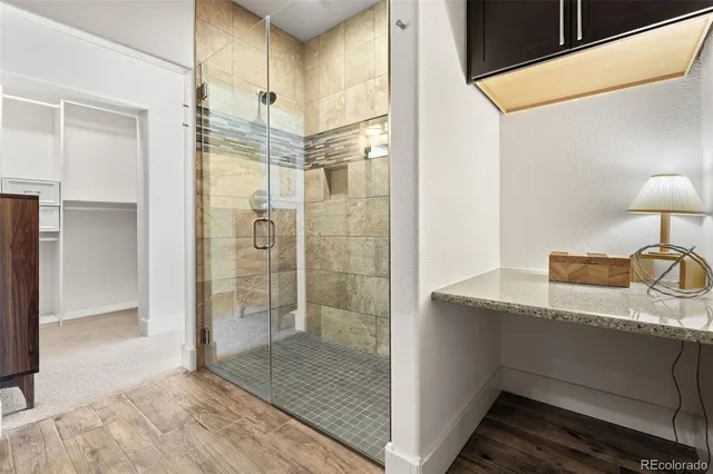 a bathroom with a granite countertop sink a shower and a mirror