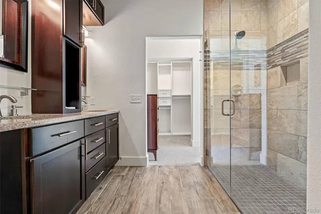 a bathroom with a double vanity sink a mirror and shower