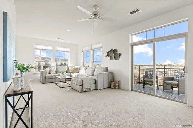 a living room with furniture and a floor to ceiling window