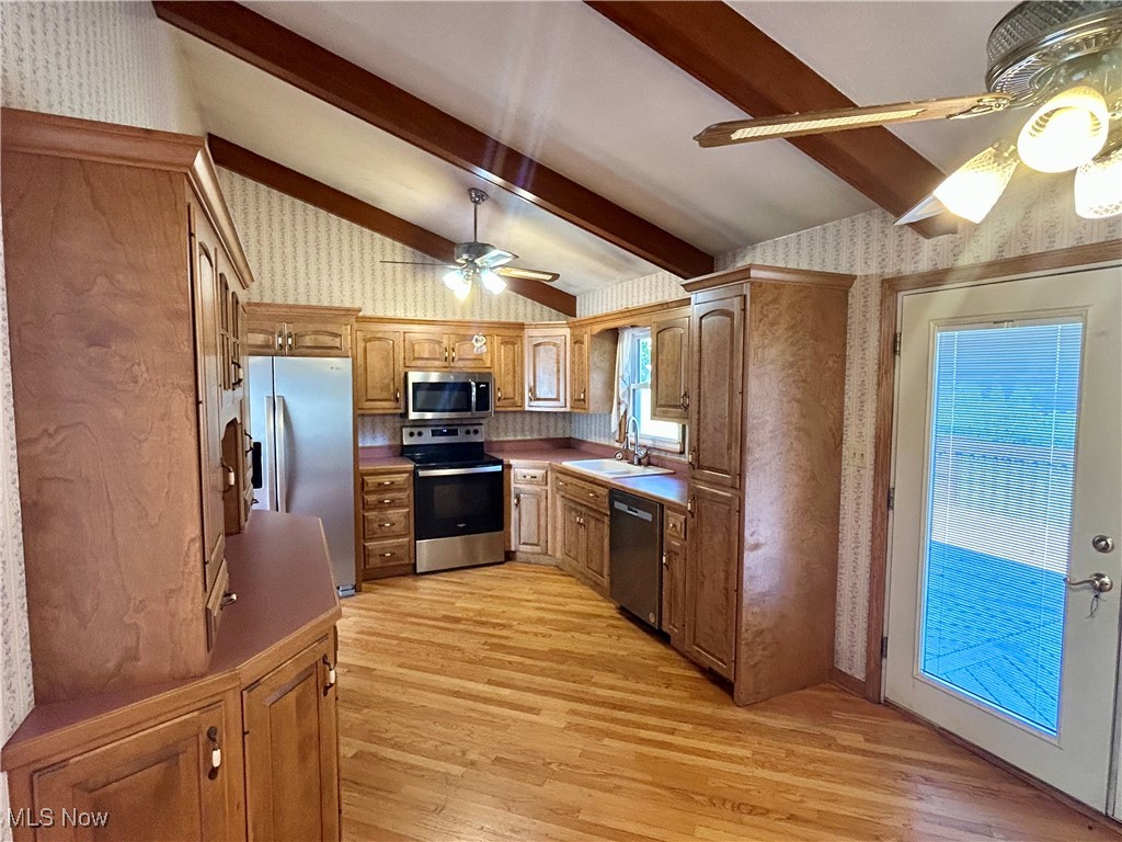 399 Abbyshire Road Green, OH 44319 - Photo 18 of 48 Kitchen view of appliances with stainless steel finishes, light wood floors, ceiling fan, and solid hardwood cabinetry, high vaulted ceiling with beams