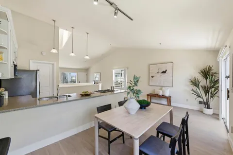 a kitchen with stainless steel appliances a table and chairs in it