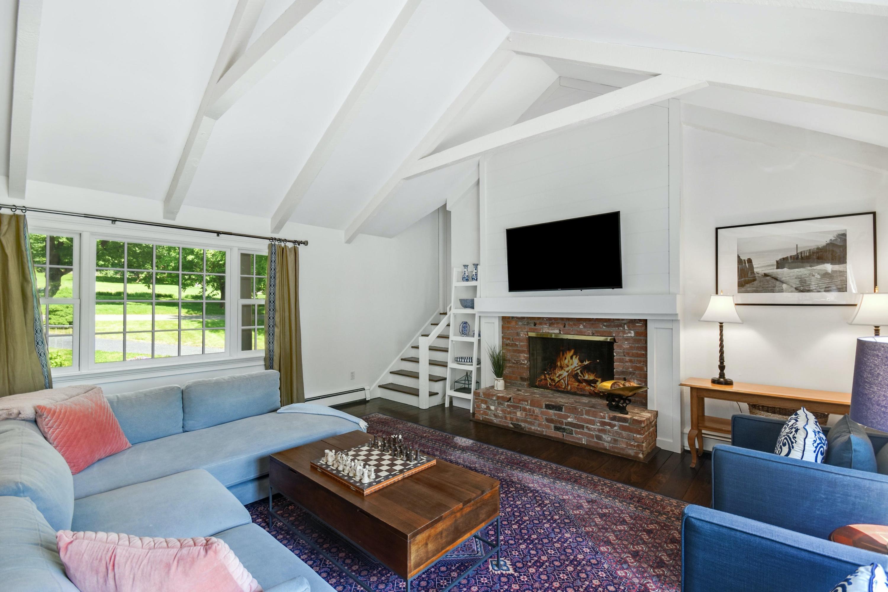 181 Brushy Ridge Road New Canaan, CT 06840 - Photo 11 of 34 a living room with furniture a flat screen tv and a fireplace