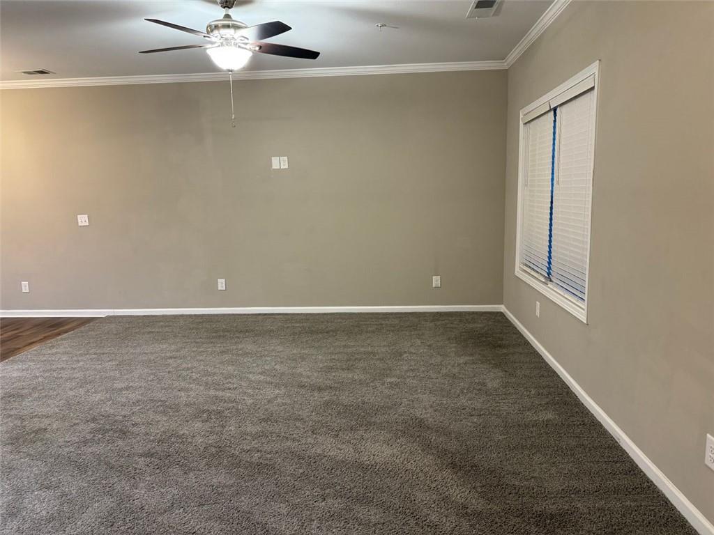 3369 Hidden Stream Court Stockbridge, GA 30281 - Photo 2 of 13 an empty room with a chandelier fan and windows