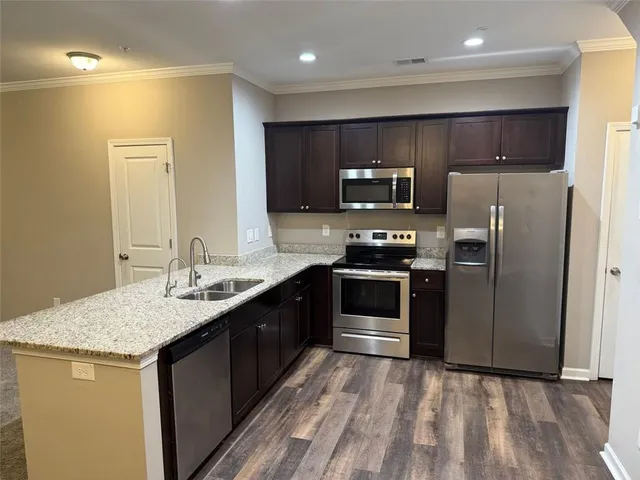 a kitchen with stainless steel appliances granite countertop a sink stove and refrigerator