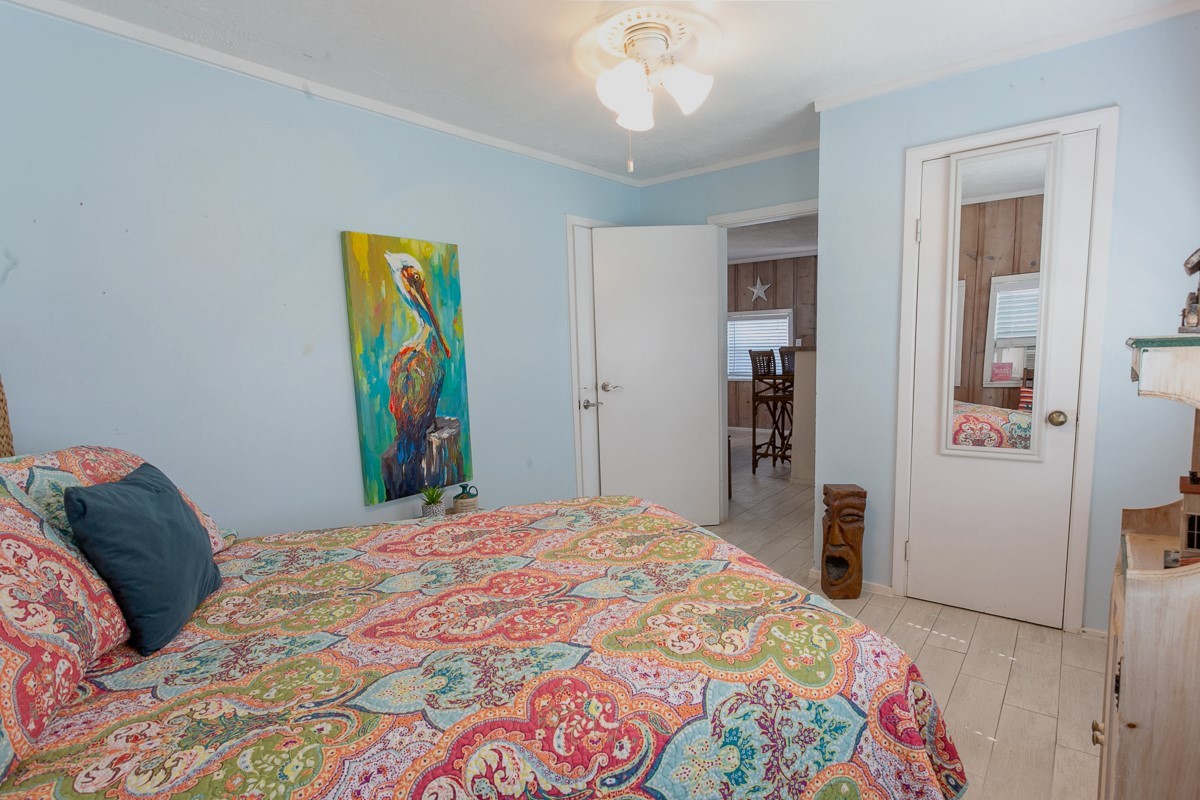 959 South East Road Crystal Beach, TX 77650 - Photo 17 of 20 a bedroom with a bed and a chandelier