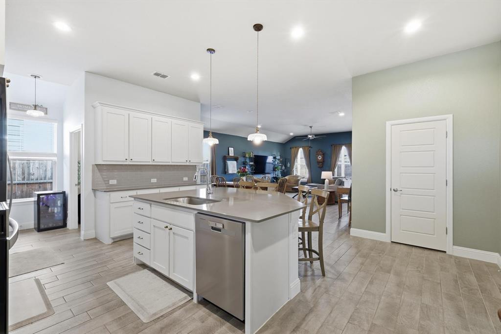 2213 Ruff Road Denton, TX 76205 - Photo 11 of 40 a kitchen with stainless steel appliances granite countertop a sink a stove a refrigerator and a dining table with wooden floor