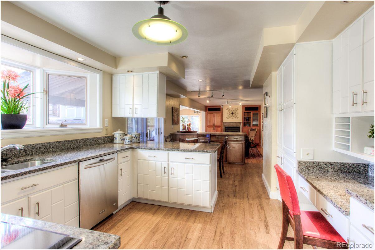 14130 Berry Road Golden, CO 80401 - Photo 7 of 28 a kitchen with stainless steel appliances granite countertop a sink dishwasher a stove and white cabinets with wooden floor