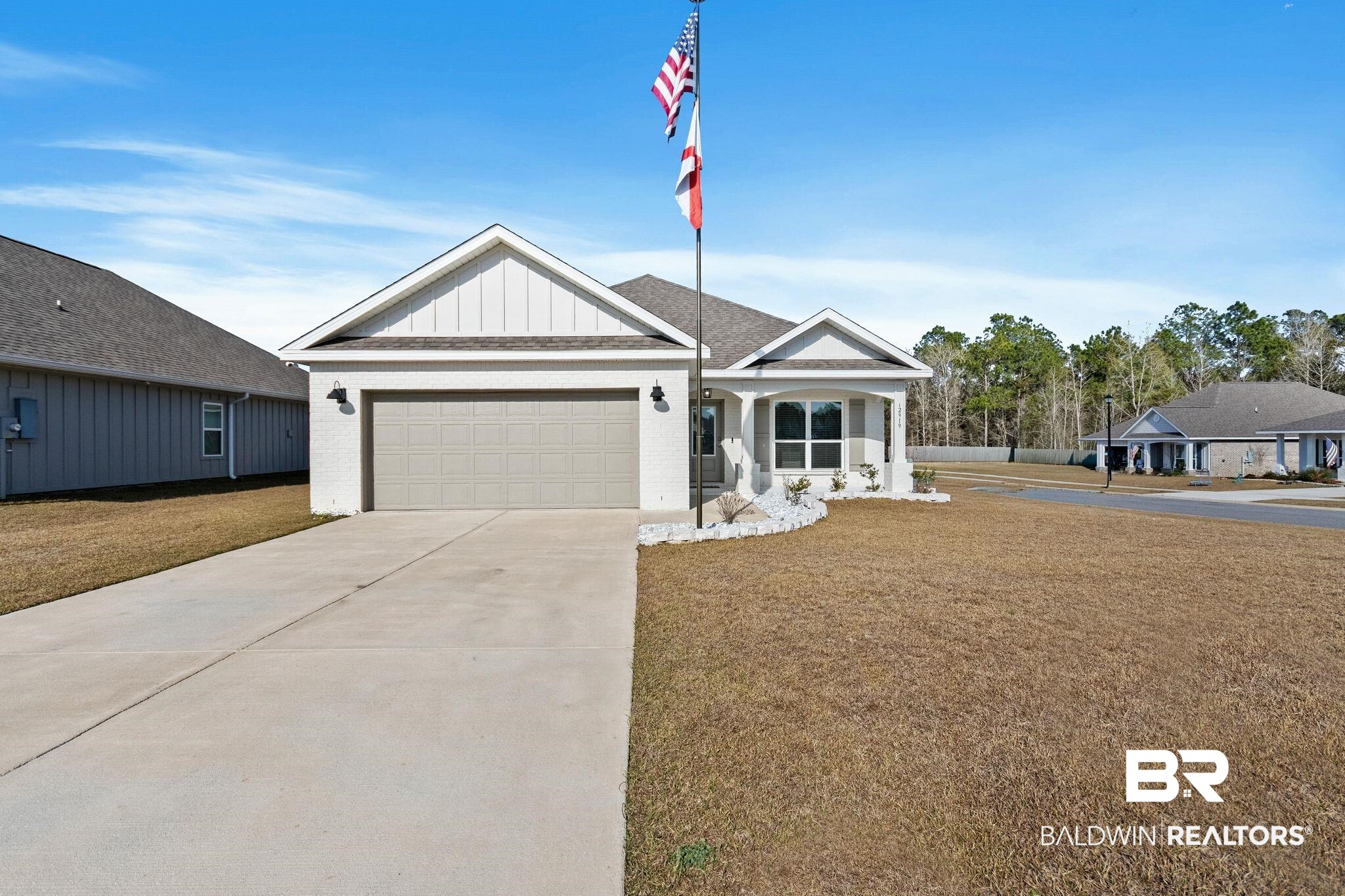 12919 Torrent Road Fairhope, AL 36532 - Photo 3 of 74 View of front of home with a front lawn, driveway, an attached garage, brick siding, and a porch