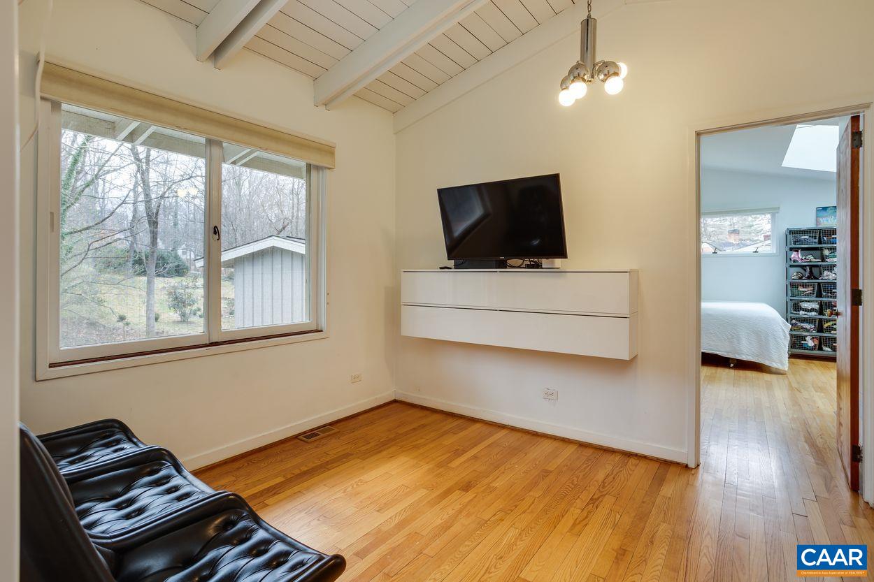 1521 Rugby Road Charlottesville, VA 22903 - Photo 12 of 27 a bedroom with furniture and a flat screen tv