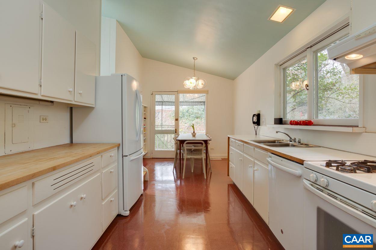 1521 Rugby Road Charlottesville, VA 22903 - Photo 17 of 27 a kitchen with stainless steel appliances granite countertop a stove and white cabinets with wooden floor