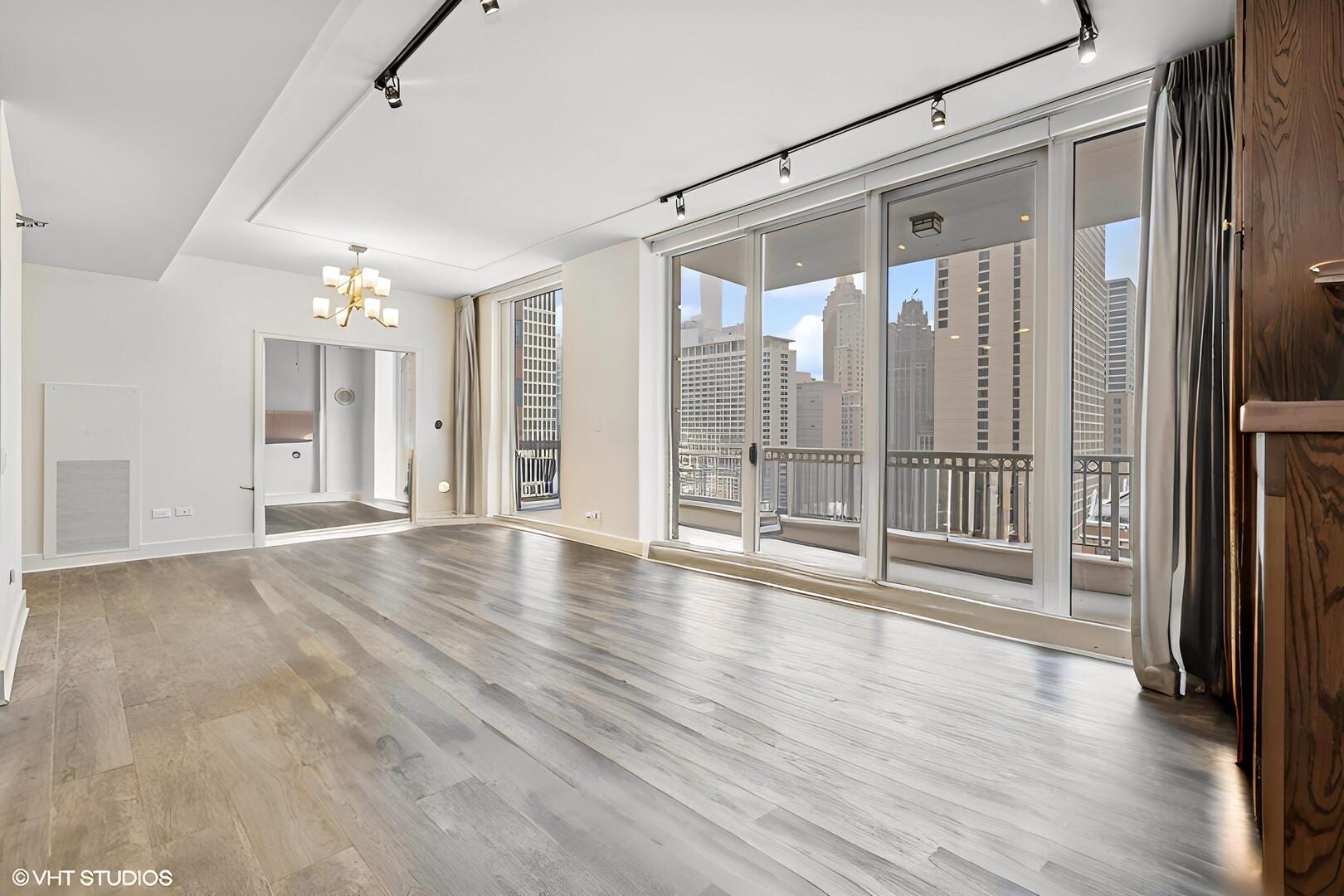 55 East Erie Street, Unit 1804 Chicago, IL 60611 - Photo 5 of 22 a view of an empty room with wooden floor and a window