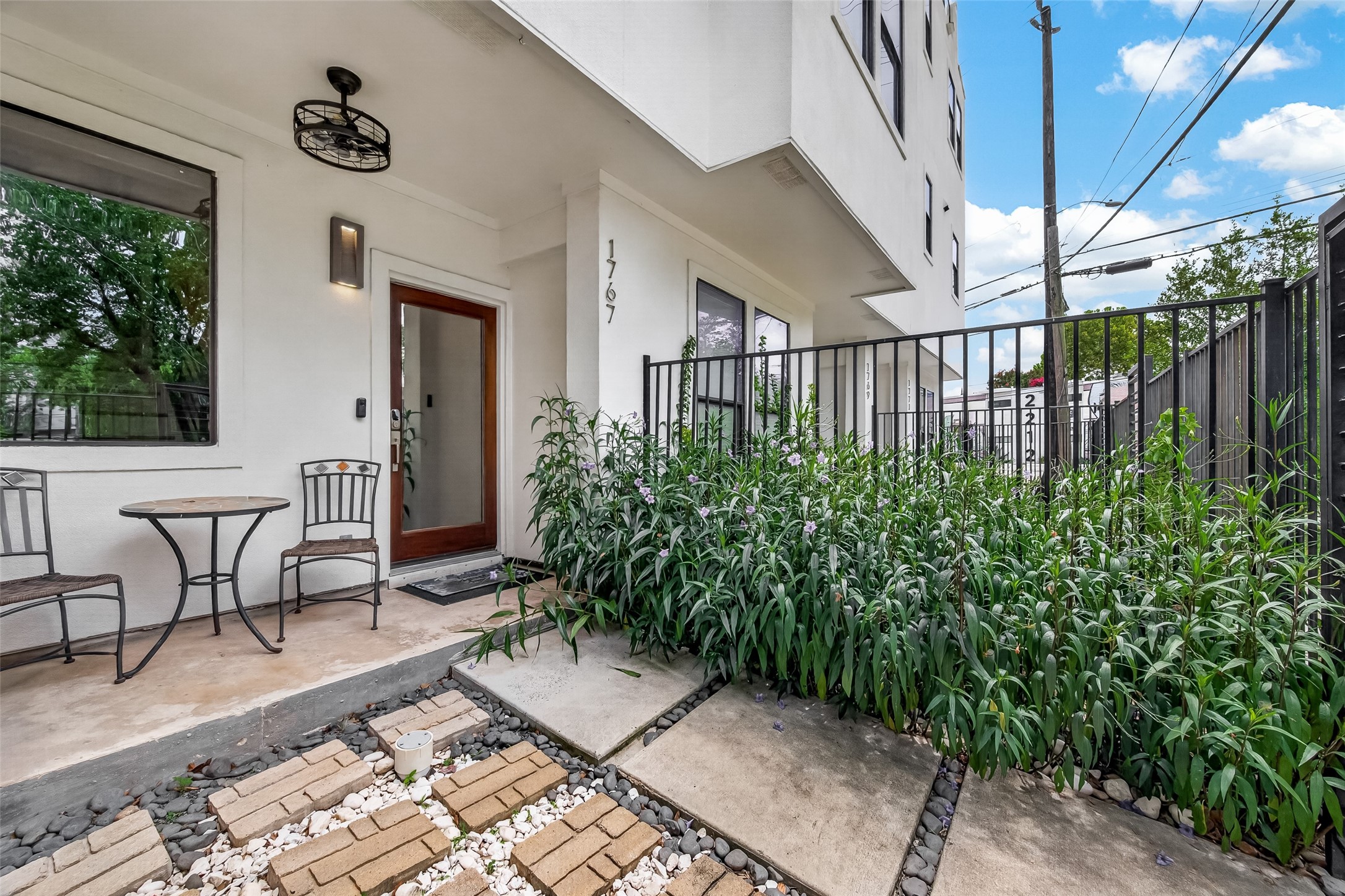 1767 Michigan Street Houston, TX 77006 - Photo 2 of 33 Charming front patio with lush greenery along a gated pathway. Perfect for relaxing and enjoying the outdoors.