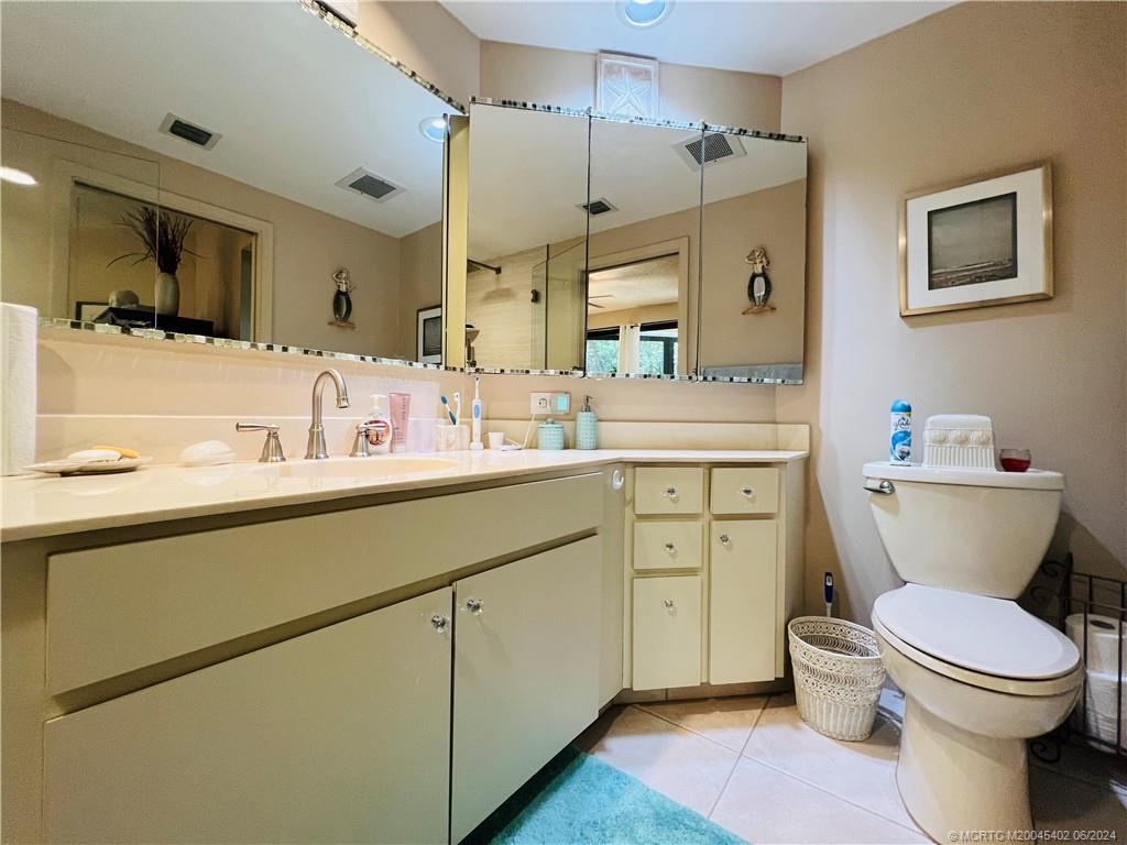 221 Northeast Plantation Road, Unit 215 Stuart, FL 34996 - Photo 38 of 83 a bathroom with a granite countertop toilet sink and mirror