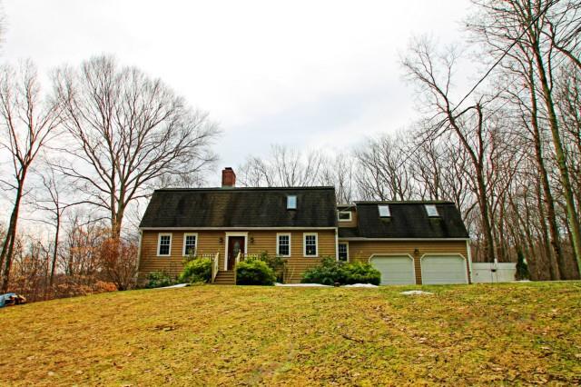 a front view of a house with a yard and trees