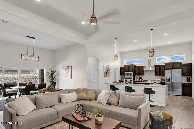 a living room with furniture a kitchen view and a chandelier