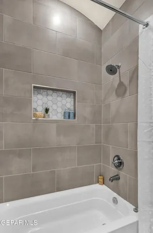 a bathroom with a white bath tub and a shower