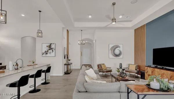 a living room with furniture a flat screen tv and kitchen view