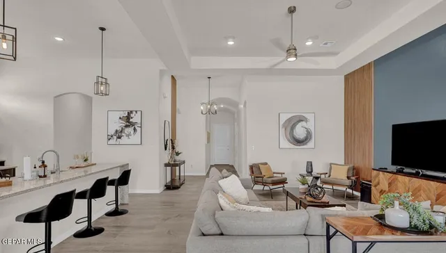 a living room with furniture a flat screen tv and kitchen view