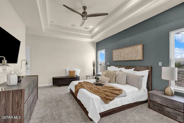 a spacious bedroom with a bed a couch and a flat screen tv